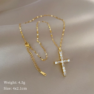 Titanium steel cross necklace with cubic zirconia on champagne silk backdrop