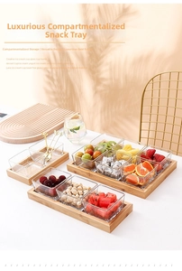 Close-up of clear glass square bowls with gold rims on a natural bamboo serving tray