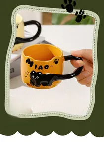 Close-up of yellow ceramic mug featuring a 3D embossed black cat tail handle
