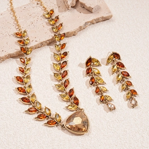 Detailed macro of vintage crystal necklace set with amber rhinestones and gold leaf pattern