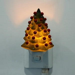 Close-up of a glowing green Christmas tree night light with warm LED lighting detail