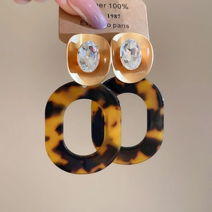 Detailed shot of retro leopard print resin earrings with golden oval crystal inlay