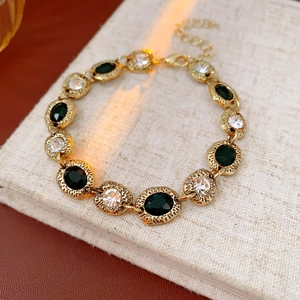 Vue macro d'un bracelet doré vintage avec pierres noires et claires sur un livre