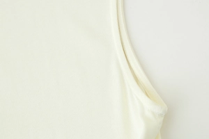 Détail des coutures et texture en maille côtelée sur la robe sans manches crème