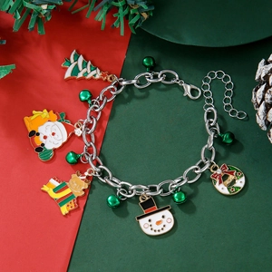 Detailed view of Christmas charm bracelet with Santa, snowman, and reindeer on festive background