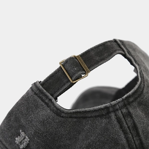 Dettaglio del cappellino grigio scuro lavato con fibbia di regolazione in metallo bronzo