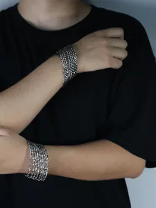 Detail of silver twisted rope chain bracelets showing metal texture on a male wrist