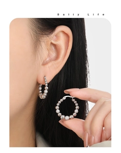 Detail of silver beaded hoop earrings featuring polished and frosted titanium steel beads