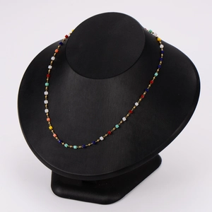 Chic gold necklace with multi-colored square beads on a black neck display model