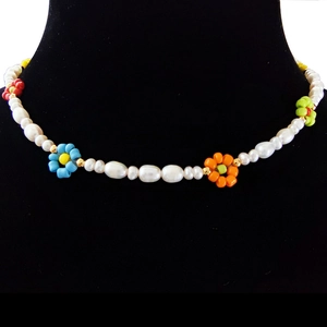 Close-up of handmade baroque pearl choker with colorful beaded flowers on black velvet