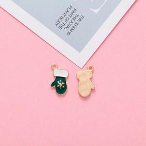 Close-up of Christmas glove charm with gold snowflakes and green enamel finish