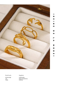 Close-up of four 18K gold-plated irregular geometric rings in a vintage wood jewelry box