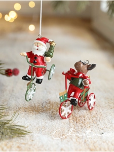 Detailed view of Santa and reindeer riding a tricycle ornament in festive Christmas colors