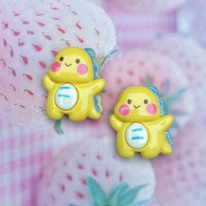 Close-up of yellow resin dinosaur charms for DIY phone cases and hair accessories