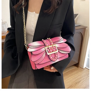 Pink shoulder bag featuring 3D butterfly wing layers with gold rivets and chain strap