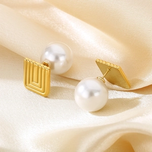 French vintage gold square earrings with white pearls on elegant beige silk fabric