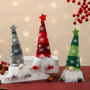 Three festive Christmas gnomes with knitted snowflake hats and glowing stars on display