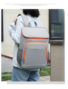 Detail view of the insulated backpack side showing mesh pocket and orange zipper accents