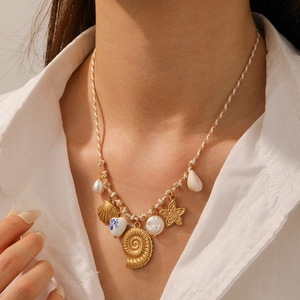 Detail of beach necklace with gold starfish, seashell charms and baroque pearls