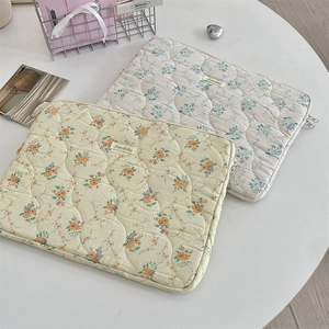 Close-up of quilted floral tablet sleeve showing soft texture and metal zipper detail