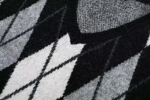 Detailed macro view of the knitted diamond pattern texture and neckline on this dress