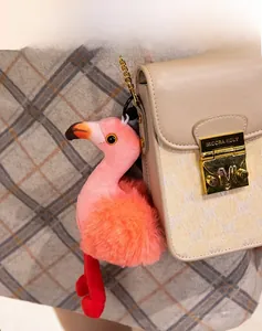 Detailed plush flamingo bag charm with pink and orange faux fur on a designer handbag