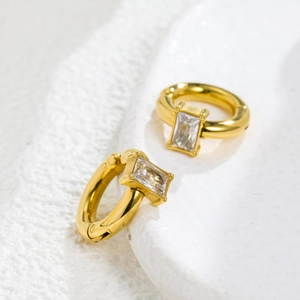 Detailed macro view of 18k gold plated huggie earrings featuring a central zircon stone