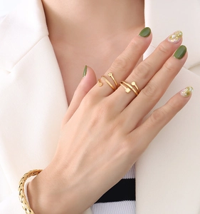 Close-up of elegant 18K gold plated minimalist rings and braided metal bracelet on model