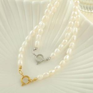 Macro di una collana di perle d'acqua dolce a due fili su un piatto a conchiglia