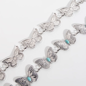 Detail of silver butterfly chain belt with turquoise inlays and engraved wings