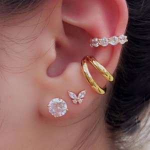 Detailed view of floral rhinestone ear cuff and stud set layered on model's ear