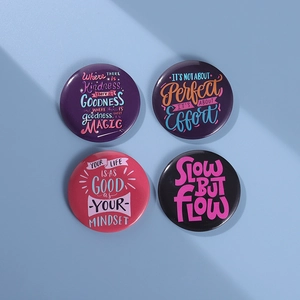 Detailed set of 4 round tinplate badges featuring motivational quotes on colored backgrounds