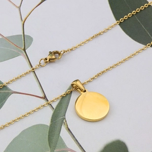 Detail of gold-plated stainless steel round pink shell pendant with lobster clasp closure