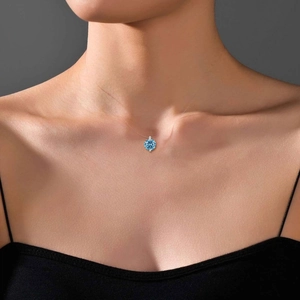 Detail of blue diamond pendant necklace with transparent invisible wire on collarbone
