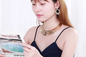 Detailed view of hollow star necklace and round earring set in gold metal finish