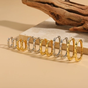 Elegant gold and silver oval hoop earrings with sparkling cubic zirconia on stone base