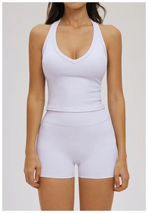 Front view of white racerback yoga top and high-waisted shorts set on female model