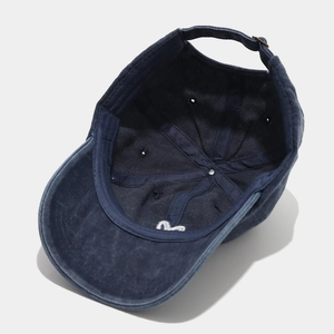 Detail of washed cotton baseball cap showing internal sweatband and adjustable metal buckle