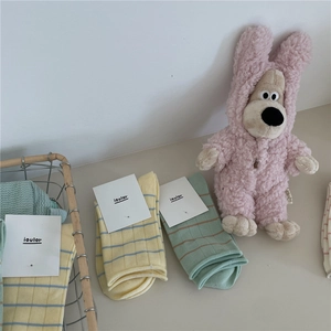 Close-up of Morandi color striped cotton socks with ioulor tags in a metal basket