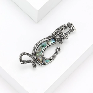 Leopard brooch with natural abalone shell inlay and silver metal texture on white background
