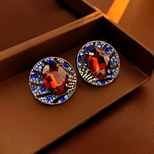 Primo piano di orecchini vintage con cristallo rosso e strass blu in cofanetto