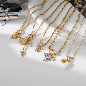 Flat lay of multiple 18K gold plated stainless steel necklaces with heart and pearl pendants