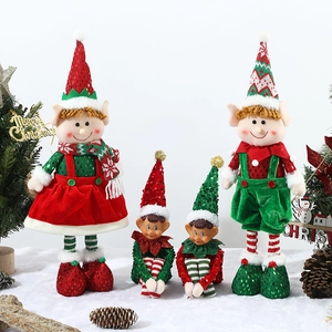 Standing and sitting Christmas elf dolls in red and green sequins on white snow