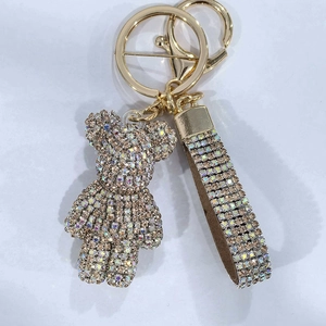 Detail of a luxury sparkling rhinestone bear keychain with a matching glittery hand strap