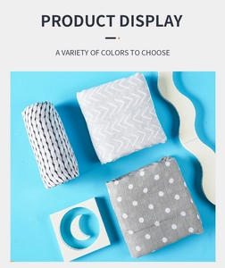 Detail of three soft muslin cotton baby blankets with dot and stripe patterns