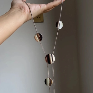 Silver Y-shaped tassel necklace featuring four minimalist round disk metal pendants