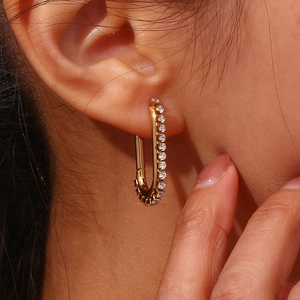 Macro view of gold-plated U-shaped earrings with sparkling cubic zirconia inlay