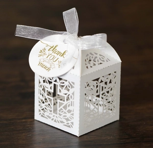 Detailoverzicht van een witte lasergesneden geschenkdoos met kruis en bedankt-label