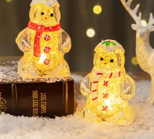 Close-up of lighted gingerbread man figurine with gold glitter and cozy scarf