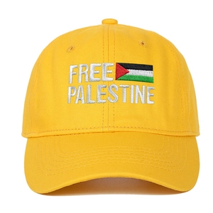 Dettaglio del ricamo Free Palestine e della bandiera sulla berretta di cotone giallo